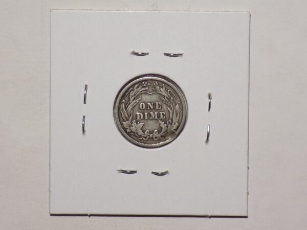 A 1916 Barber Dime is sitting on top of a white piece of paper.