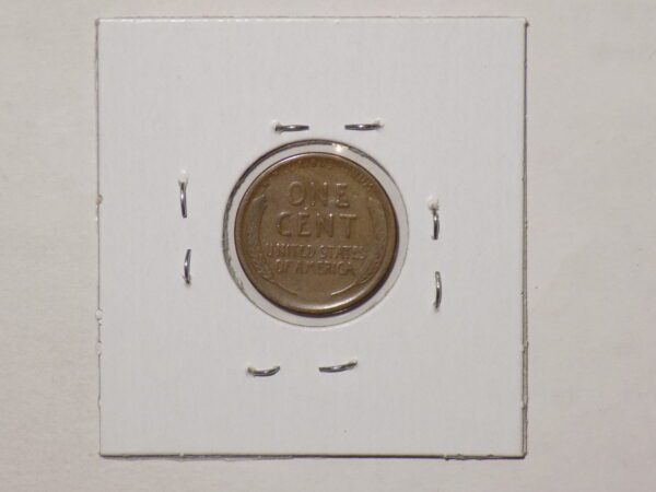 A one cent coin is sitting on a white piece of paper.