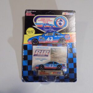 A blue and white nascar toy car in its packaging.