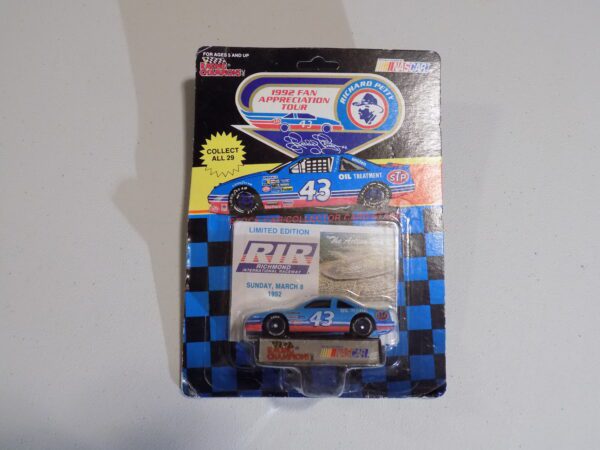 A blue and white nascar toy car in its packaging.