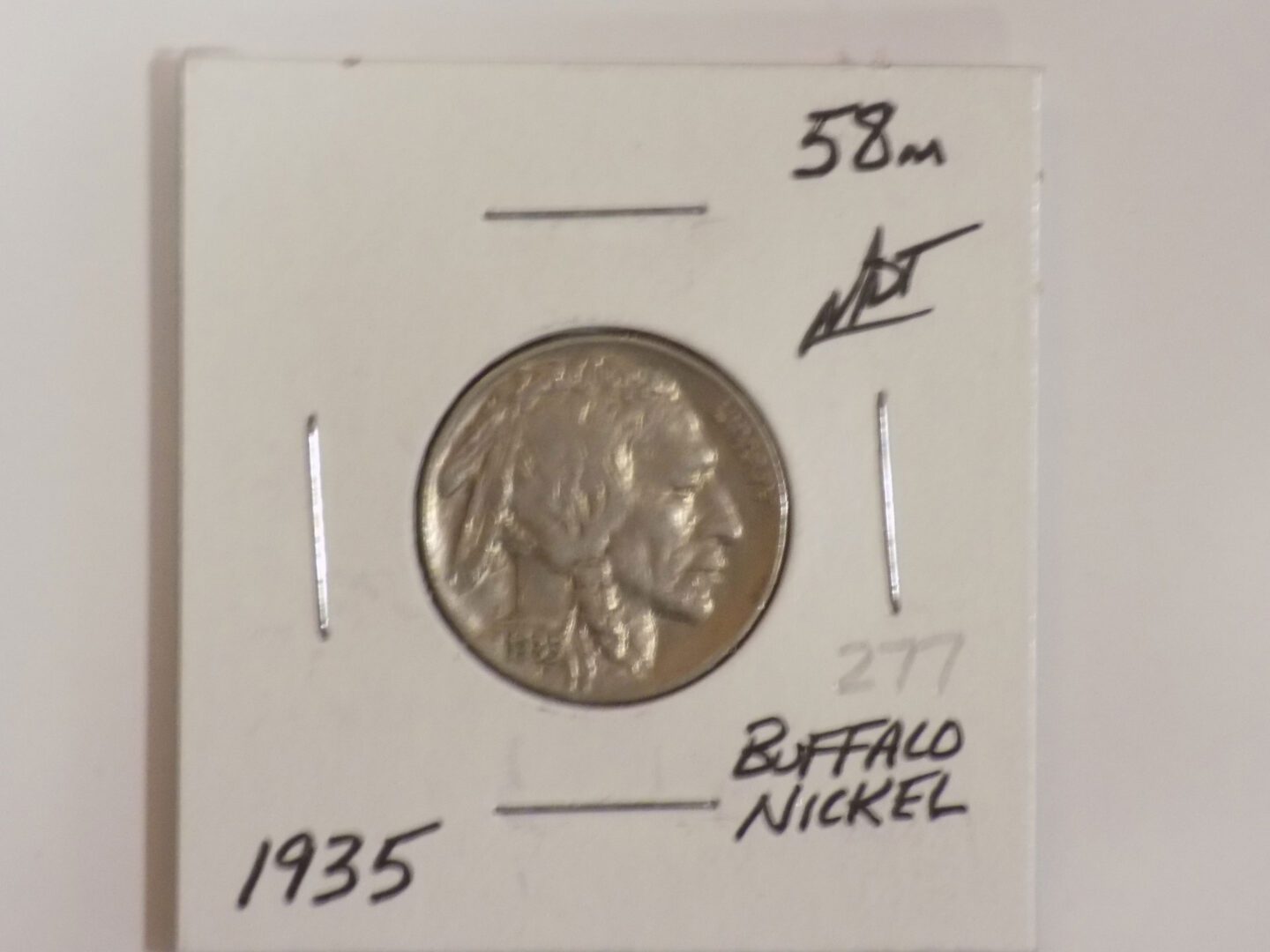 A buffalo nickel is shown on a piece of paper.