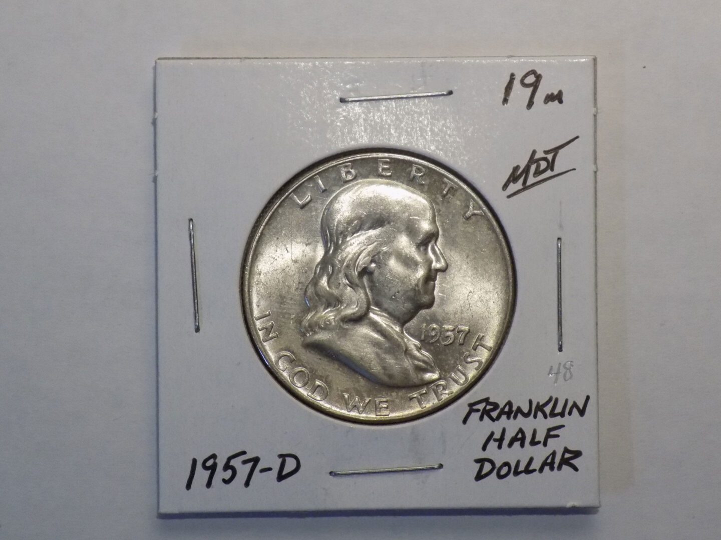 A silver franklin dollar in a box.