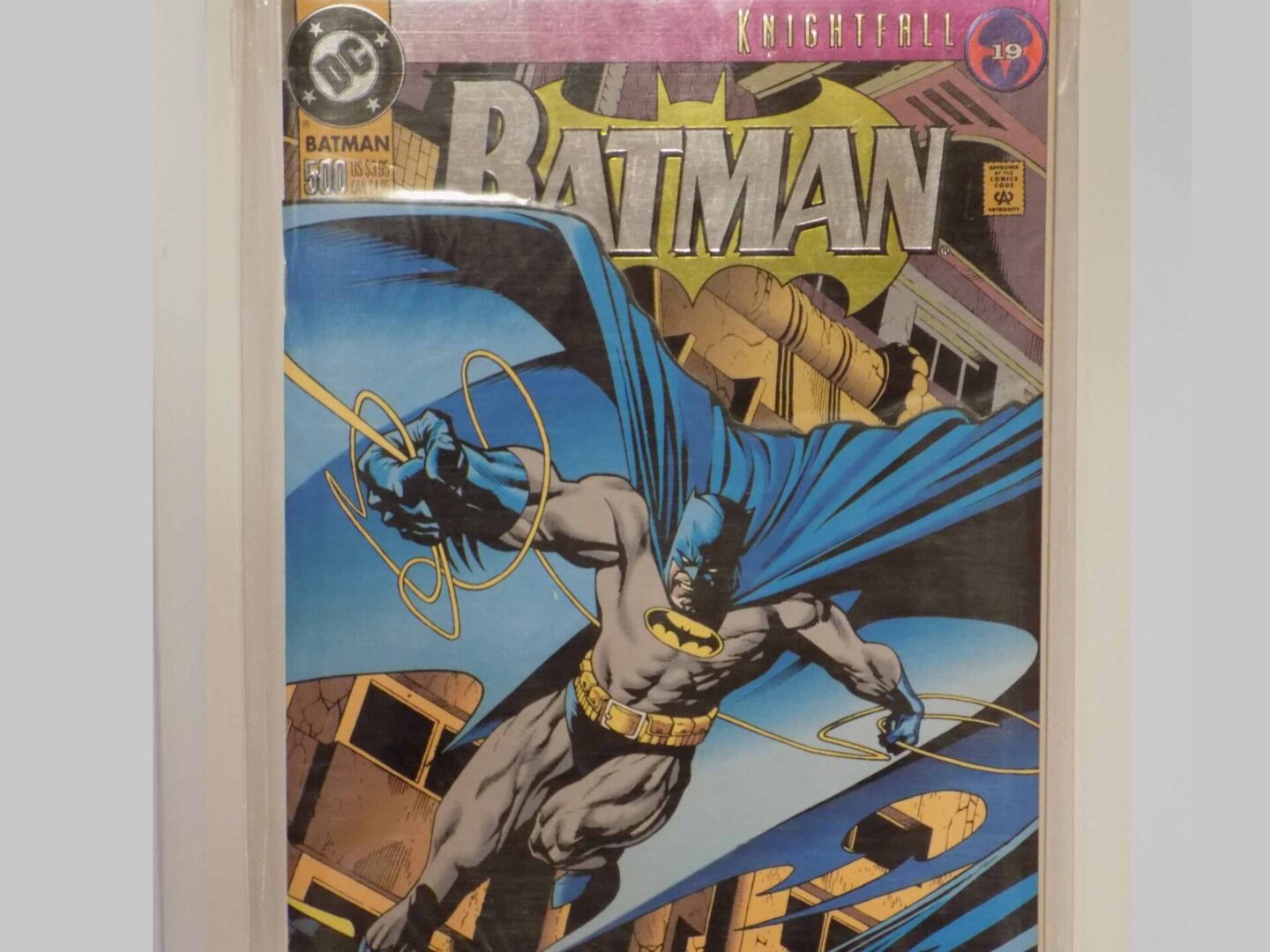 A batman comic book in a cgc case.