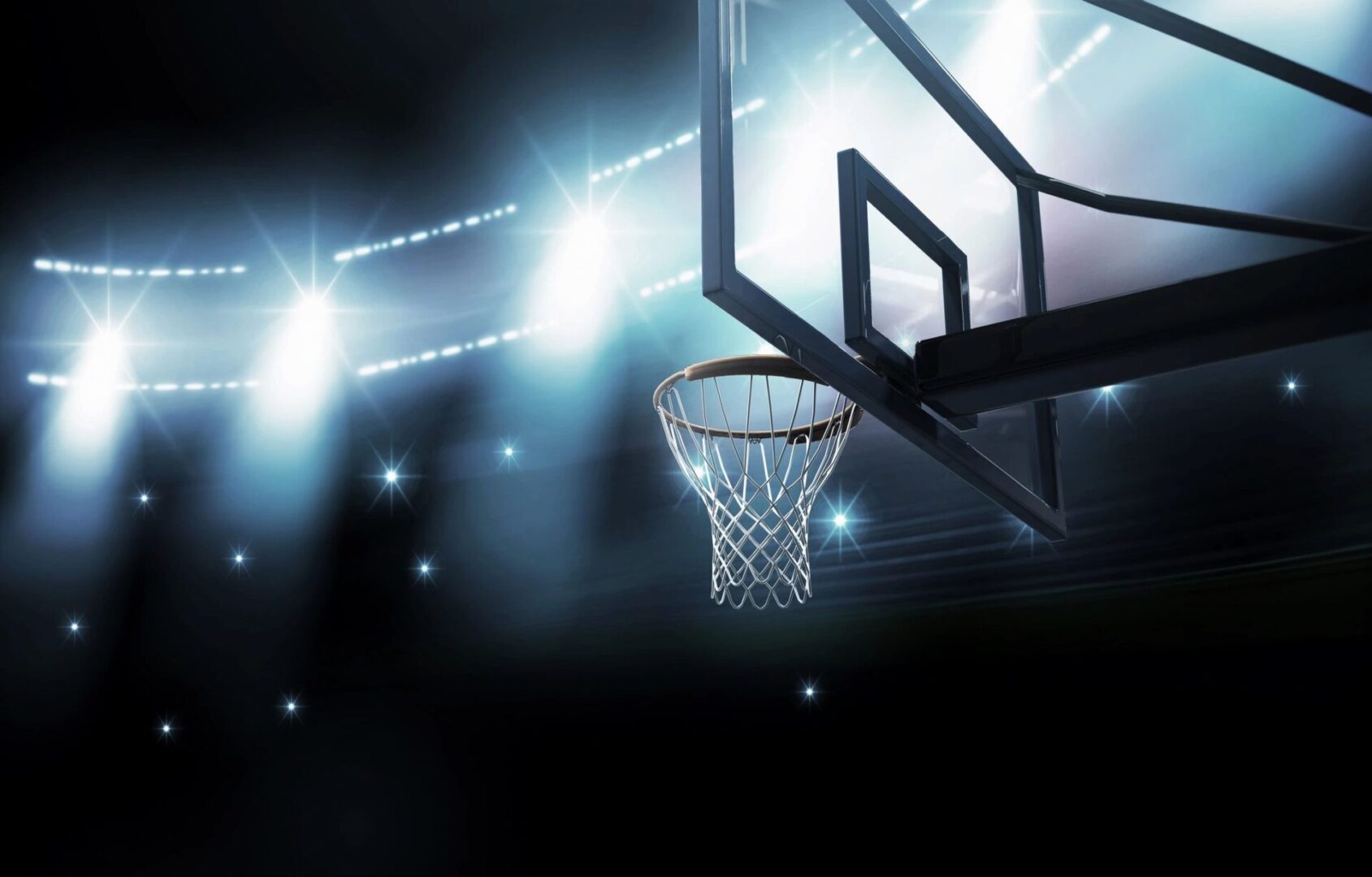 An image of a basketball hoop in a dark arena.