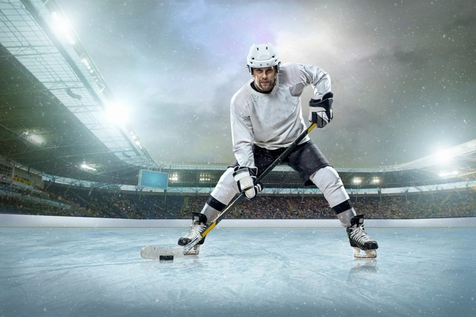 A hockey player is playing on an ice rink.