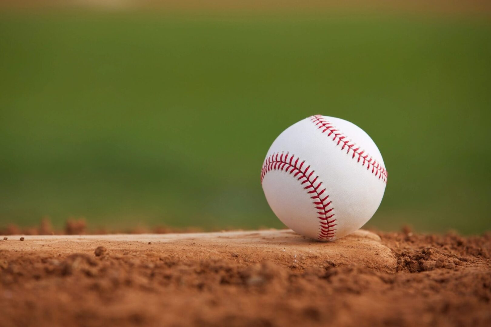 A baseball sits on top of a baseball bat.