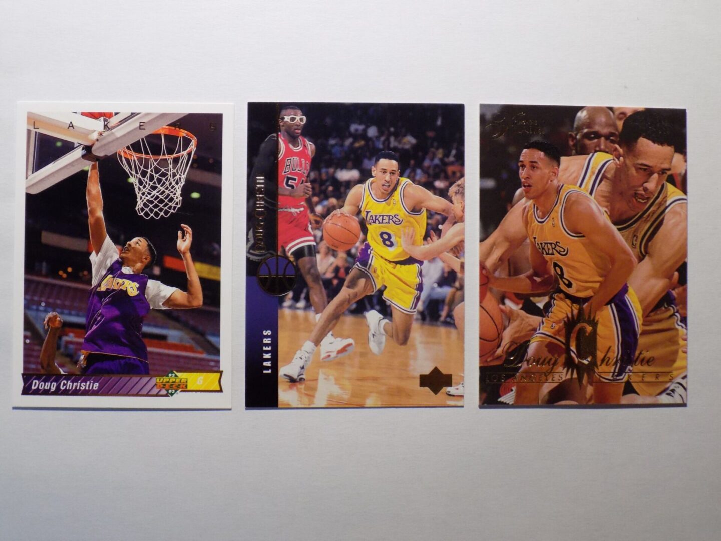 Three Christie, Doug basketball cards with a basketball player in the middle.