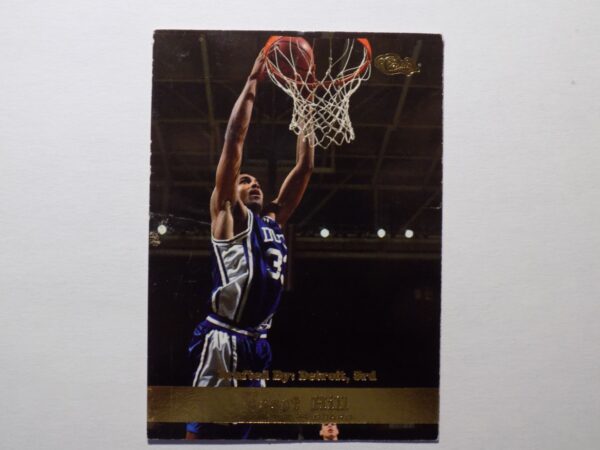 A Grant Hill basketball card with a player dunking the ball.