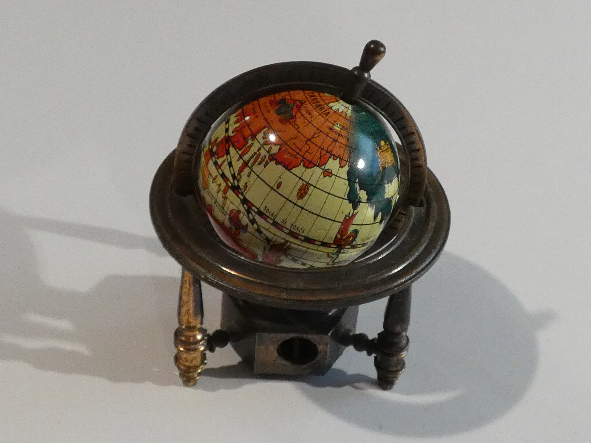 Vintage globe pencil sharpener on stand.