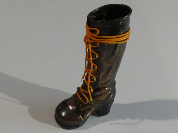 Black leather boot with yellow laces.