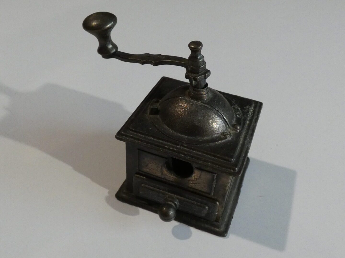 Vintage metal pencil sharpener shaped like a coffee grinder.