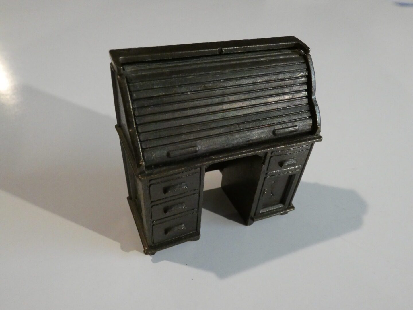 A miniature wooden rolltop desk.