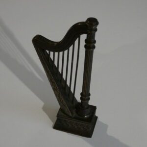 Ornate metal harp figurine on white background.