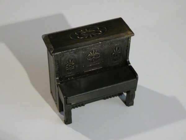 Black miniature piano with ornate details.