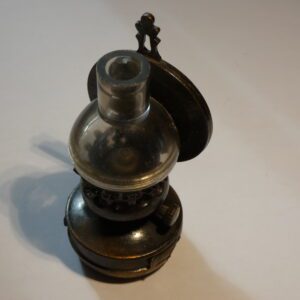 Antique metal pencil sharpener shaped like a lamp.