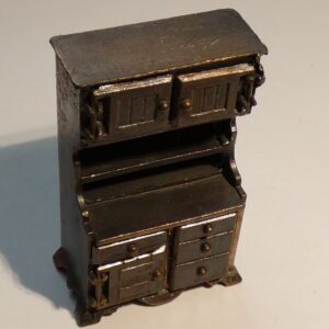 Vintage metal pencil sharpener shaped like a cabinet.