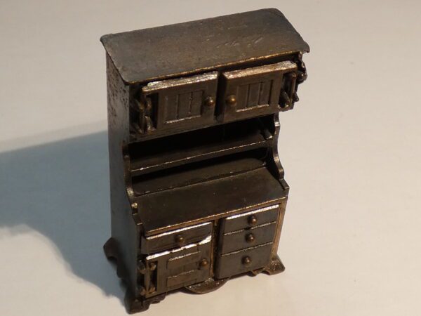 Vintage metal pencil sharpener shaped like a cabinet.