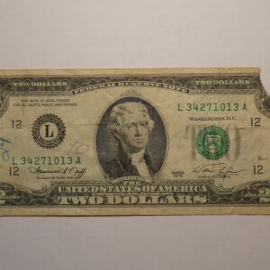 Two dollar bill with a torn corner.