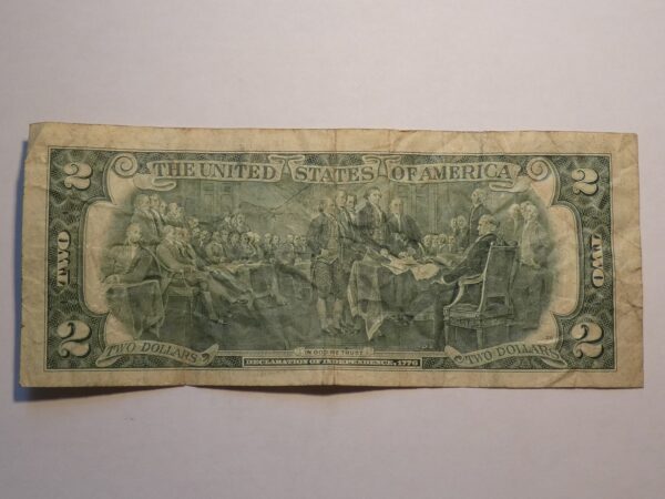 Two dollar bill with Declaration of Independence scene.