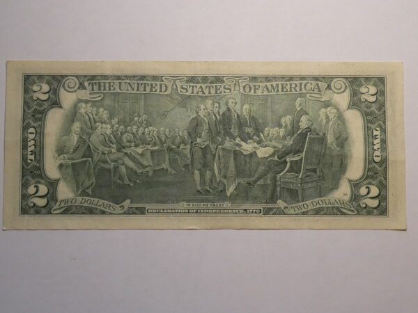 Two dollar bill featuring Declaration of Independence scene.