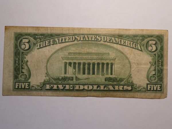 Five dollar bill with Lincoln Memorial.