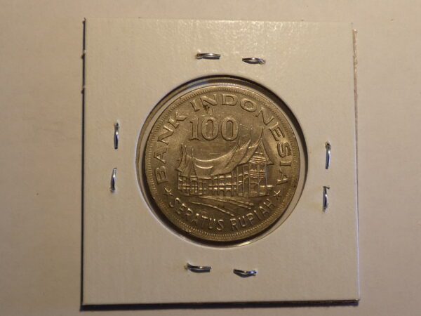 Indonesian 100 Rupiah coin with building image.