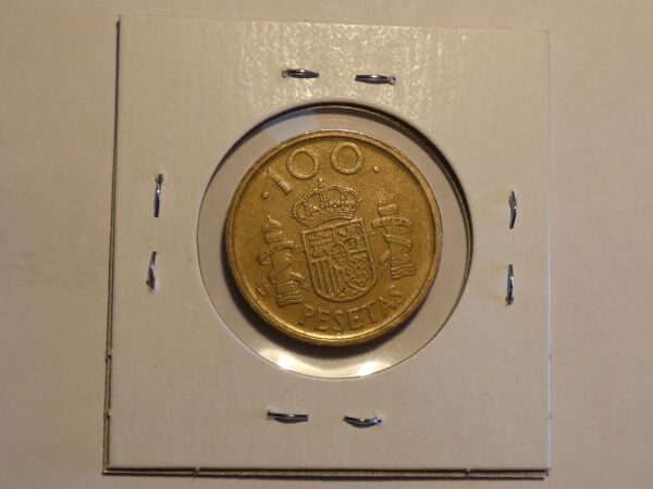 Spanish 100 pesetas coin in holder.