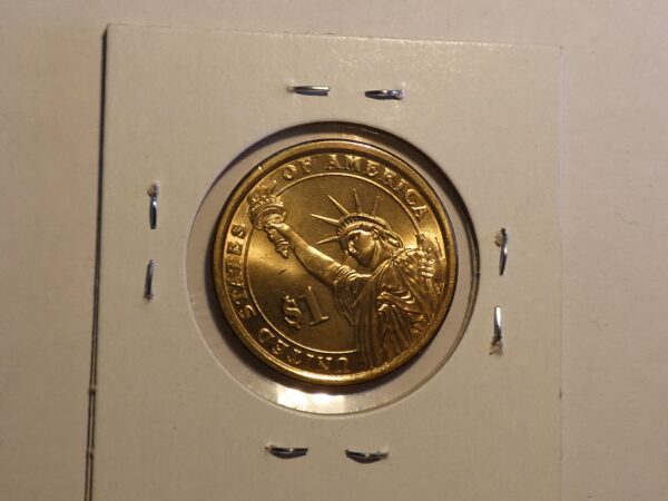 Gold one dollar coin with Statue of Liberty.