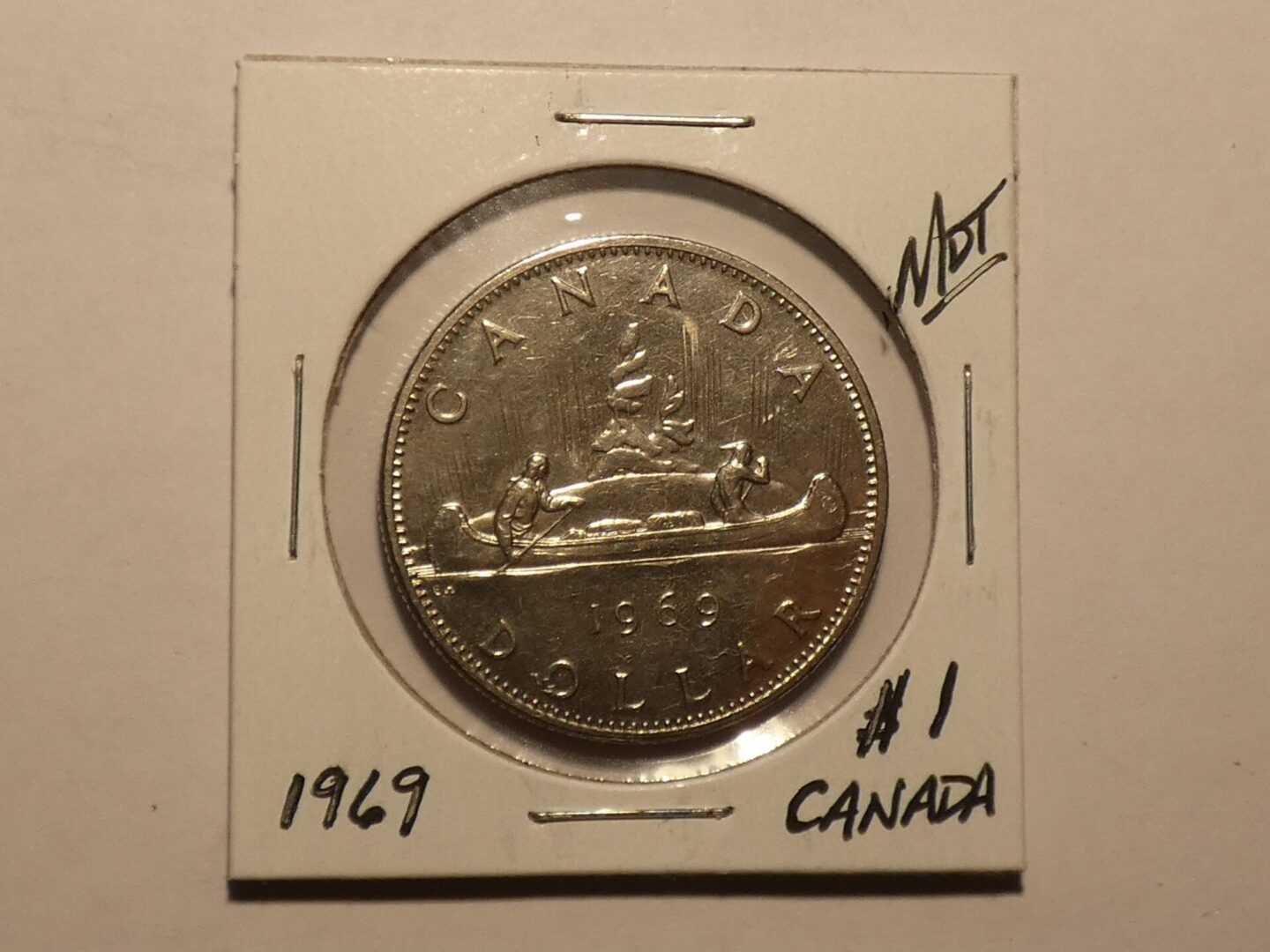 1969 Canadian dollar coin with canoe.